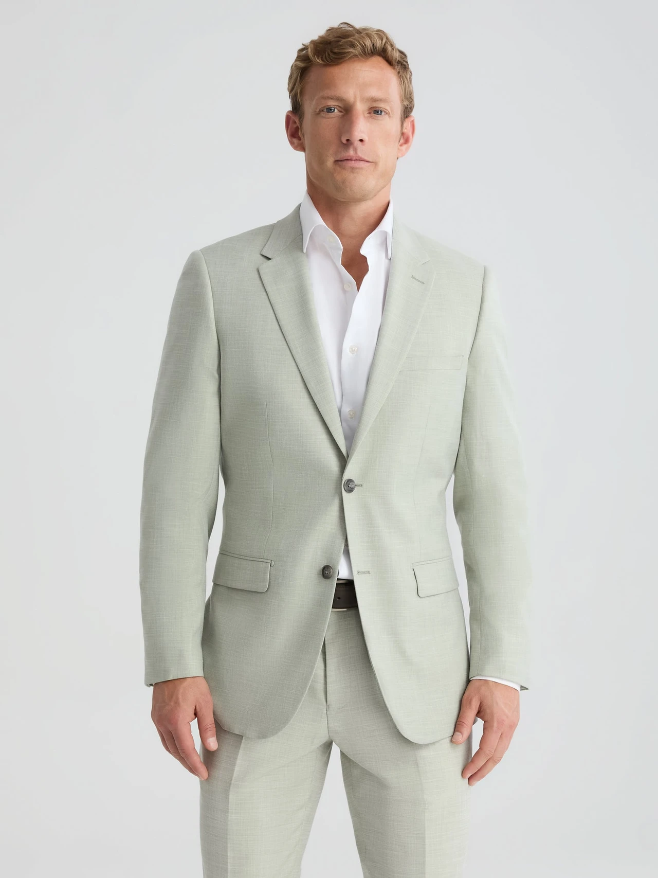 groom wearing linen sage green suit for beach wedding