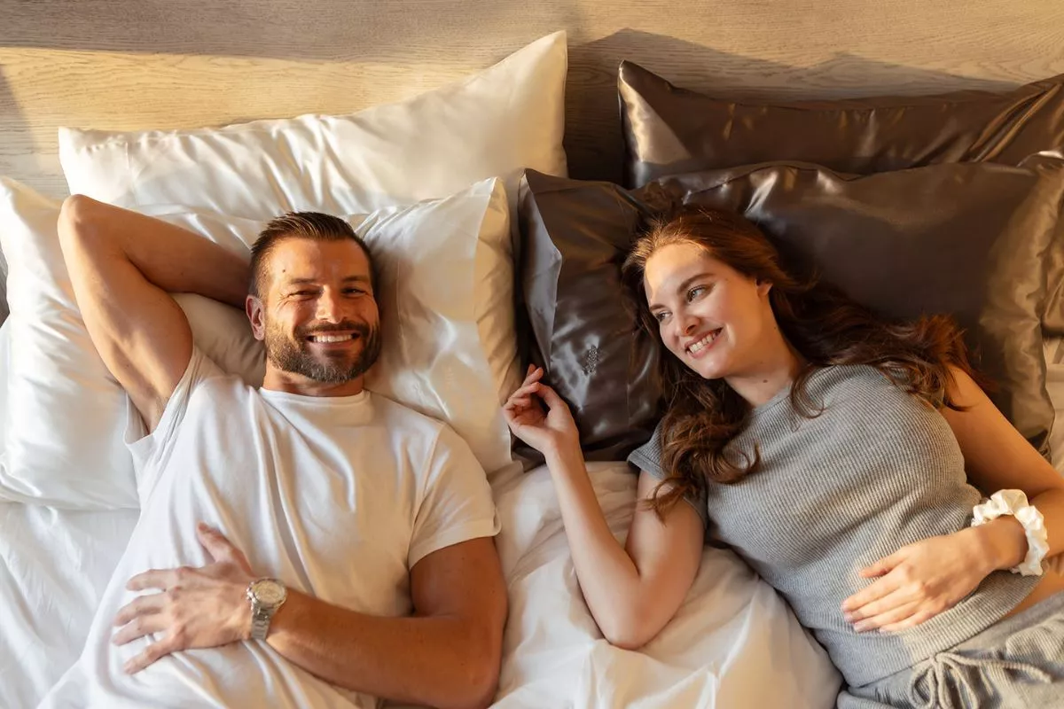 couple laying on mulberry silk pillowcases by homebdy