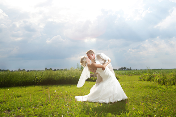 KimAnne Photography - iowa backyard wedding - bride-groom-kiss-outdoors-under-sun