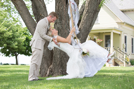 KimAnne Photography - iowa backyard wedding - groom-pushes-bride-on-swing