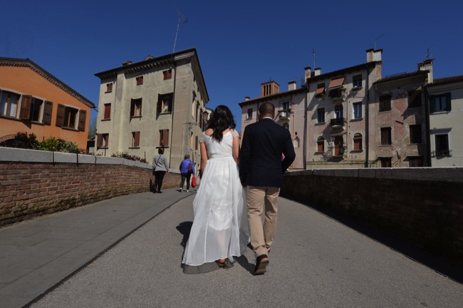 bride and groom walk across bridge at their spring wedding in Italy | Planner: Venice Events | via https://emmalinebride.com/real-weddings/spring-wedding-in-italy-andre-shona/