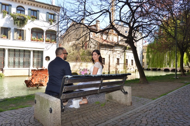 bride and groom sit on bench in Treviso | Planner: Venice Events | via https://emmalinebride.com/real-weddings/spring-wedding-in-italy-andre-shona/