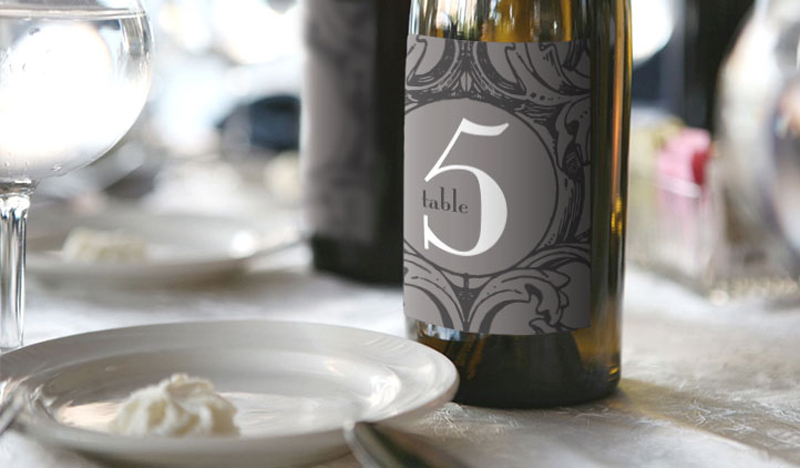 use a bottle of wine and these wedding wine labels as a table number at your reception. guests can find their table and sip on your favorite wine choices all in one! via emmalinebride.com