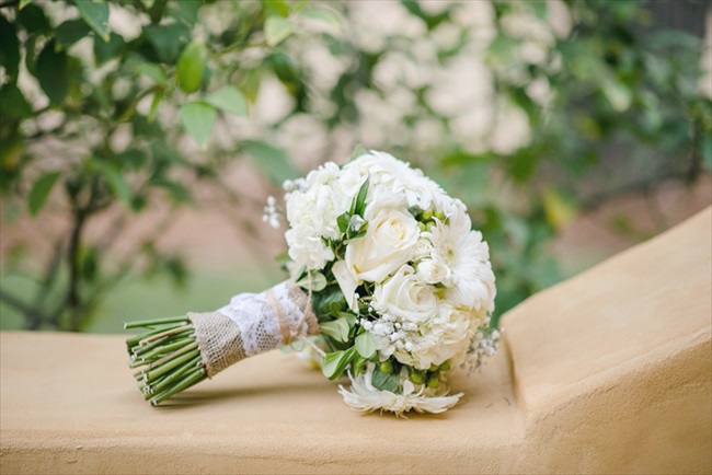 the bouquets and boutonnieres were filled with white roses; the bride's bouquet also featured white gerbera daisies