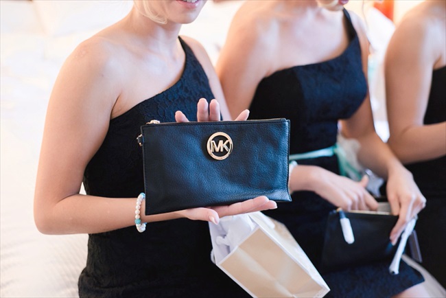 the bridesmaids received customized clutch purses in black.  their bridesmaid dresses were black with a one shoulder style neckline