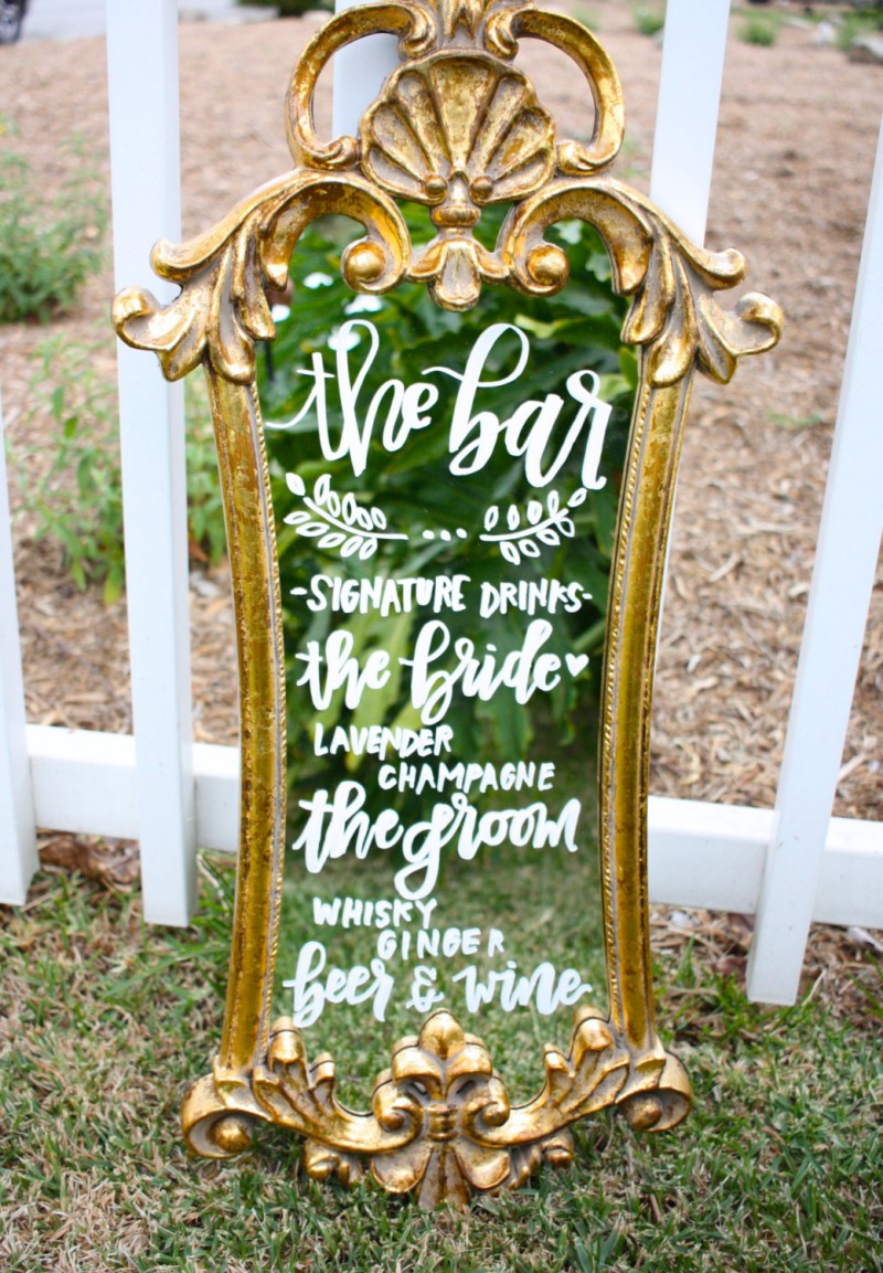 This decorative bar mirror is one of our favorite wedding mirror signs!  It's ideal for displaying a signature cocktail. | https://emmalinebride.com/decor/wedding-mirror-signs/
