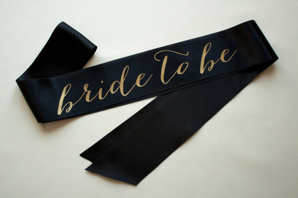 black bride to be sash with gold | stylish bachelorette sash ideas | via https://emmalinebride.com/bride/bachelorette-sash-ideas/