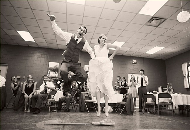 bride and groom jumping the broom at wedding photographed by third line studios