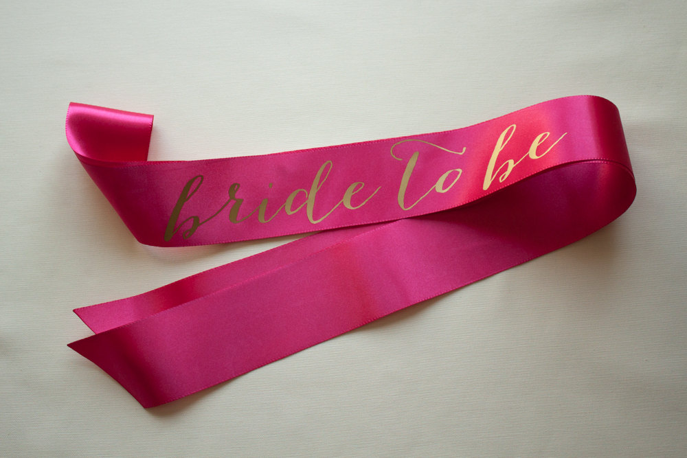 bride to be gold on hot pink sash | stylish bachelorette sash ideas | via https://emmalinebride.com/bride/bachelorette-sash-ideas/