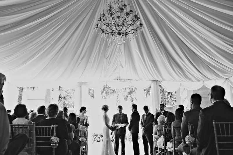 The bride and groom held their ceremony under a beautiful chandelier in a tented space, where the reception would occur shortly after. | Photographer: Melissa Prosser Photography | via https://emmalinebride.com/real-weddings/colleen-ryans-lovely-savannah-wedding-at-the-mansion-on-forsyth-park