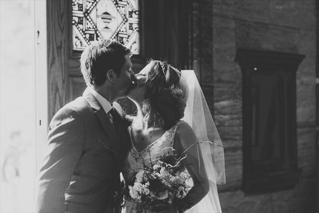 The bride and groom kiss | Photo: Searching for the Light Photography LLC | via https://emmalinebride.com/real-weddings/colorado-chic-wedding-kendall-brian/