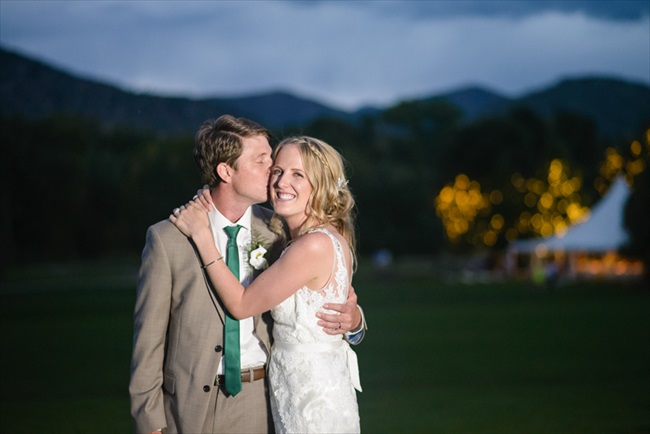 The groom kisses his bride | Photo: Searching for the Light Photography LLC | via https://emmalinebride.com/real-weddings/colorado-chic-wedding-kendall-brian/