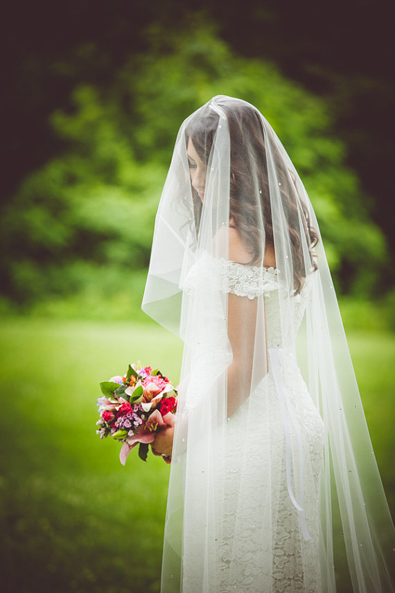 bride wearing long length wedding veil covering her face