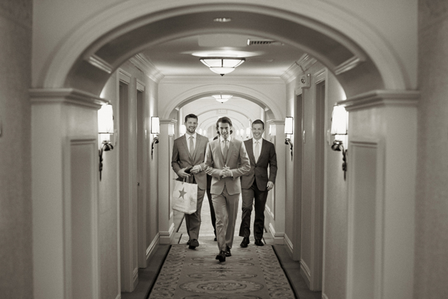 groom with groomsmen walking dawn hallway at Connecticut waterfront wedding - photo: Melani Lust Photography | via https://emmalinebride.com