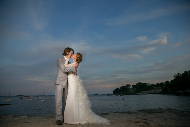 bride and groom kiss in Greenwich Harbor at Connecticut wedding - photo: Melani Lust Photography | via https://emmalinebride.com