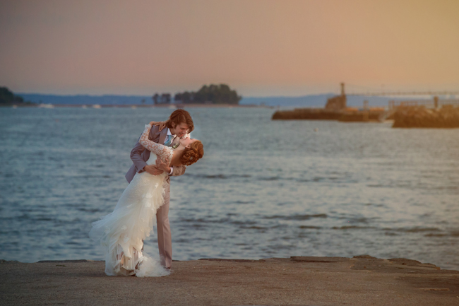 groom dips bride in Greenwich Harbor at Connecticut wedding - photo: Melani Lust Photography | via https://emmalinebride.com