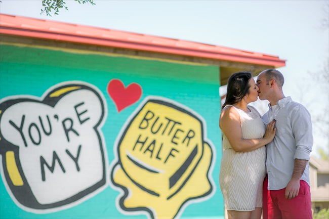 couple kisses by graffiti saying 