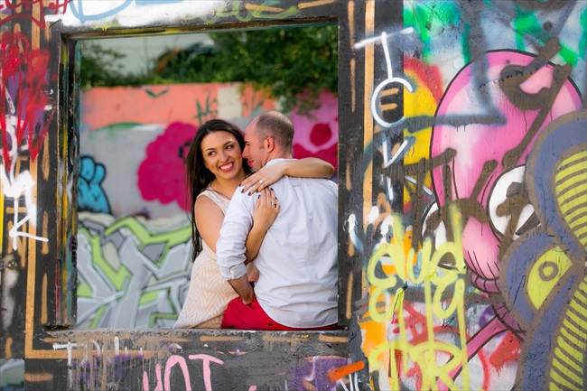 couple takes photo by graffiti at their Fun Austin Engagement Session | Photographer: Adrianne Riley Photography | via https://emmalinebride.com/real-weddings/fun-austin-engagement-session-priscella-jerry/