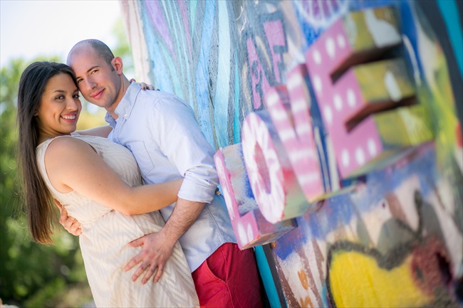 couple embraces by love sign at their Fun Austin Engagement Session | Photographer: Adrianne Riley Photography | via https://emmalinebride.com/real-weddings/fun-austin-engagement-session-priscella-jerry/