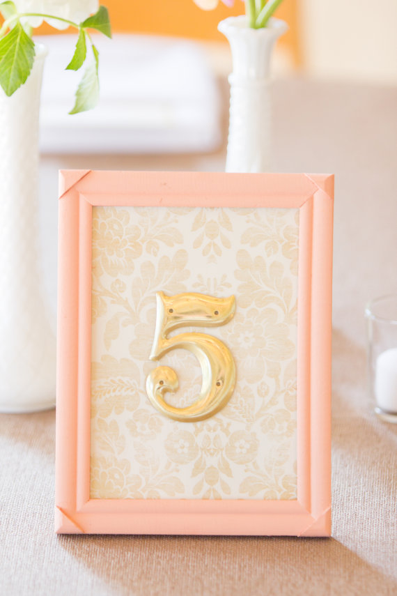 Gold Table Numbers with Peach Frame (by River Kiss Weddings via Emmaline Bride)