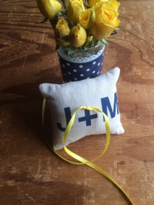 ring bearer pillow with initials blue text and yellow ribbon