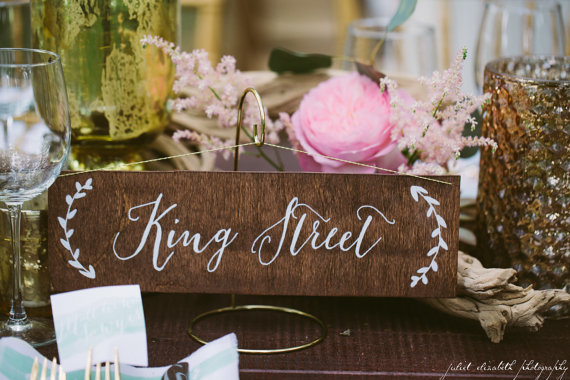 Use table names at your wedding instead of table numbers. Cute and creative idea! Sign by Paper and Pine Co. | Photo: Juliet Elizabeth Photography | table names weddings - http://emmalinebride.com/reception/table-names-weddings/