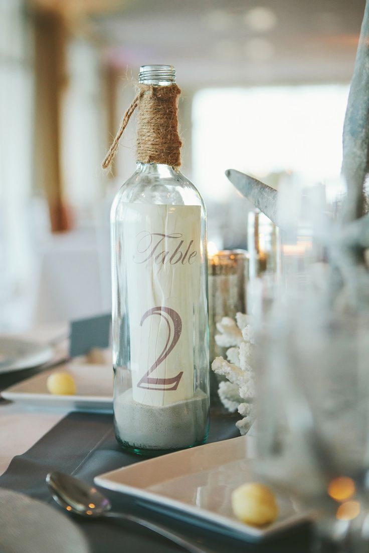 table number bottles for beach wedding | photo: monika gauthier | via decorate for beach wedding ideas from emmalinebride.com