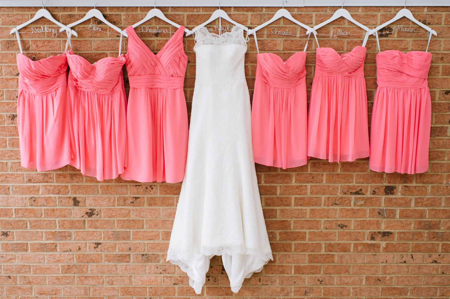wedding-dress-with-personalized-hanger-next-to-bridesmaid-dresses-with-personalized-hangers